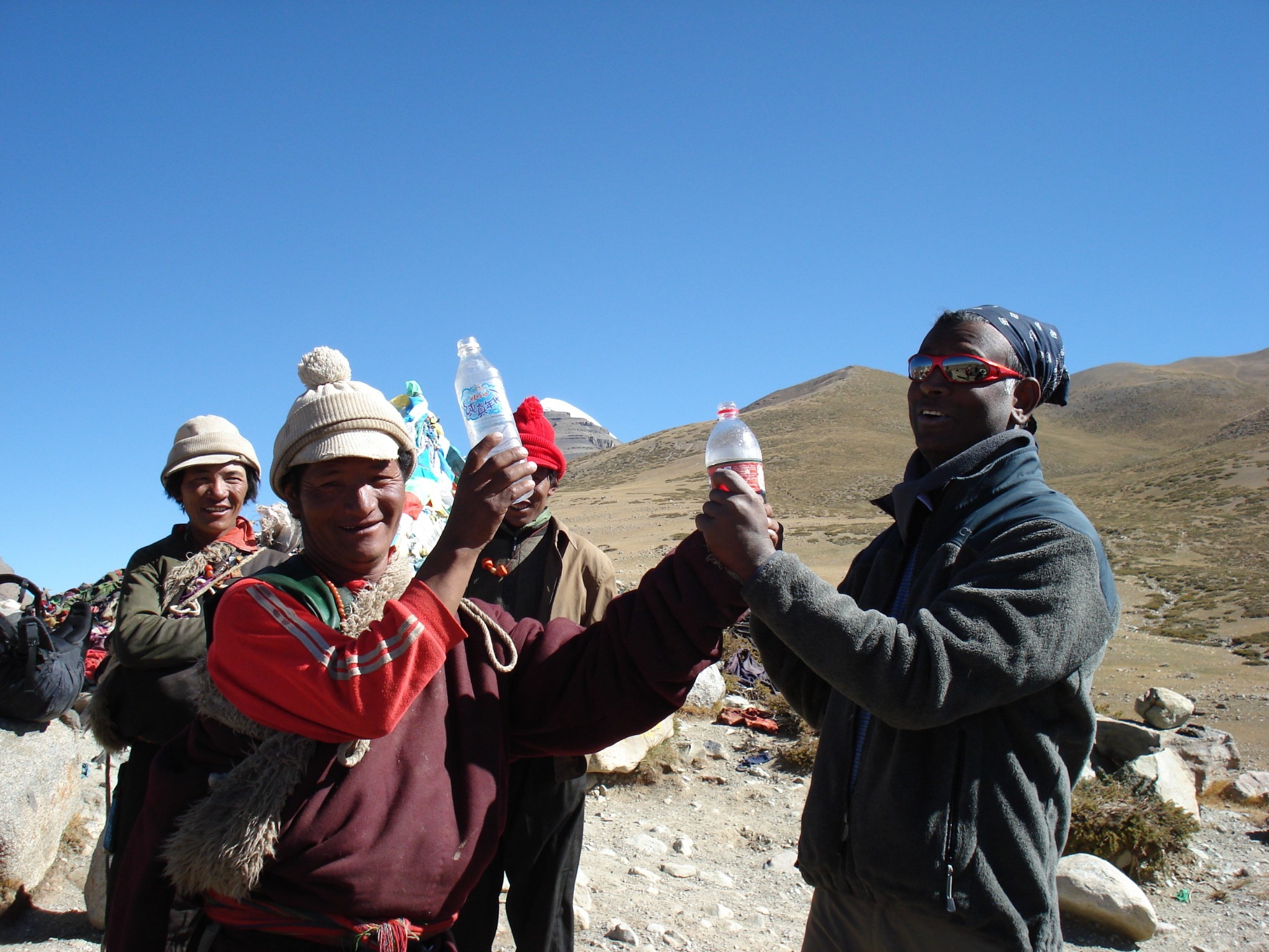Rajan stösst während seiner Tibetreise mit Menschen am Kailash an.