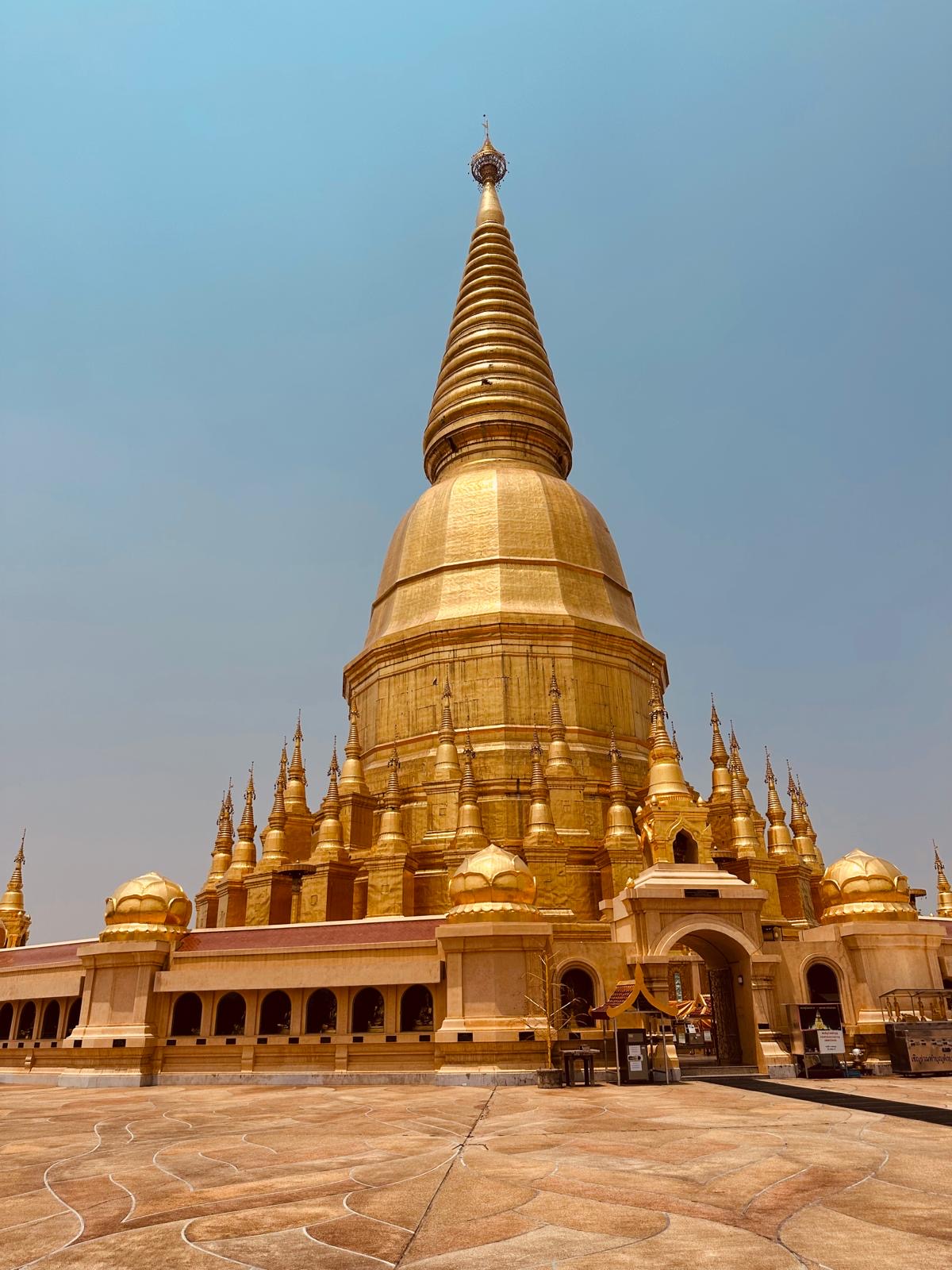 Die goldene Chedi Si Wiang Chai in Li, Provinz Lamphun, mit kleineren Türmen und einem weiten Vorplatz.